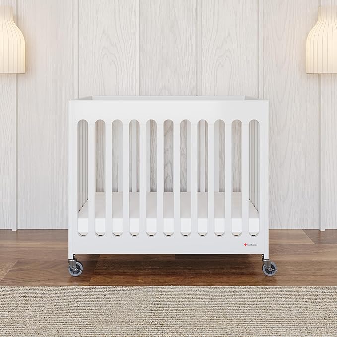 Foundations Boutique Folding Mini Baby Crib - Compact, Portable, Wooden Hotel Crib, Foldable Compact Cribs for Baby & Toddlers - Includes 3" Foam Mattress - White